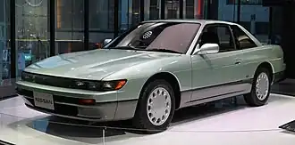 Front view of a two-door car with door mirrors