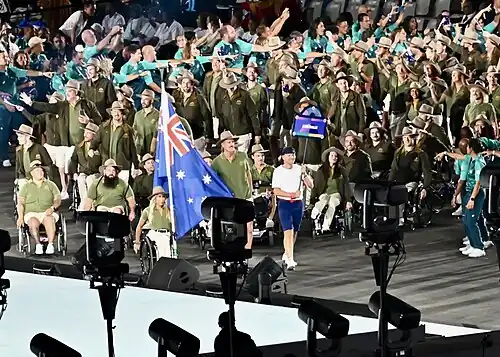 Australian contingent enters with the flag carried by Madison de Rozario and Brenden Hall