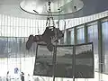 A visitor is suspended from the ceiling to navigate in a virtual reality.