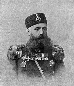 A man in a formal military uniform poses for a photo