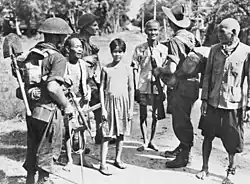 Image 50Australian soldiers and local civilians on Labuan Island. The soldier on the left is armed with an Australian-designed Owen gun. (from Australia in World War II)