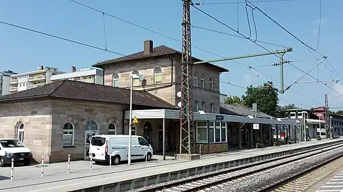 Square two-story stone building with hipped roof