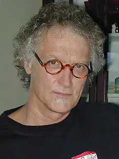 Bill Davis standing and smiling, wearing glasses