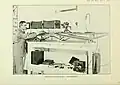 Sepia photograph of man adjusting photographic equipment on a bench