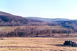 Picture of Bunch almost hidden in the trees from about 1 mile north. There is a Kansas City Southern freight-train just across the road
