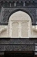 Stucco and wood carvings on one of the lateral galleries of the courtyard