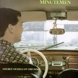 A photograph shot from the back of a car of a man driving