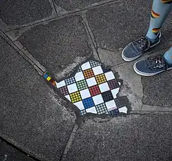 A mosaic on a sidewalk by Ememem
