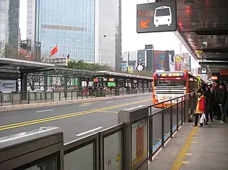 Passengers and a bus at a station