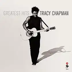 A black-and-white photo of Chapman playing guitar in a desert