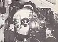 The starboard 12-inch (305 mm) Mark VIII gun in one of the turrets aboard the battleship HMS Illustrious. The gun's breech is open.
