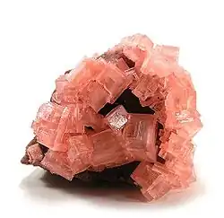 Image 26Pink cubic halite (NaCl; halide class) crystals on a nahcolite matrix (NaHCO3; a carbonate, and mineral form of sodium bicarbonate, used as baking soda). (from Mineral)