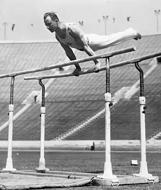 Heikki Savolainen competing on the uneven bars.