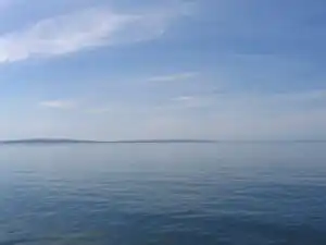 Large bodies of water such as oceans manifest water's inherent blue color.
