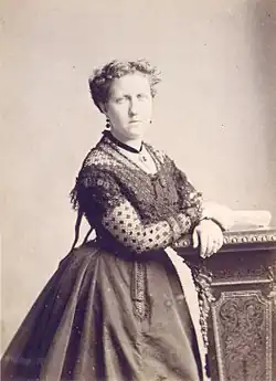 Head and shoulders photograph of a middle-aged Isabel wearing a flower hat