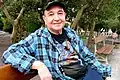 A man wearing a cap is sitting on a bench