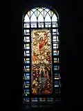The large stained-glass window by the main altar depicting the Resurrection of Christ