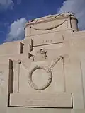 The memorial's sarcophagus, crown and wreath carvings, and the English inscription.