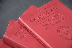 several red hard cover books in a pile