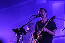 Thom Yorke playing guitar and Nigel Godrich performing