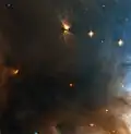 A small region of NGC 1333 taken by Hubble Space Telescope.[13] The bi-polar object in the upper part is HH 4