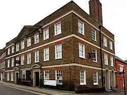 an old three-storey brick building, viewed from its corner