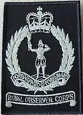 1986 pattern badge, worn on the right breast of green coveralls; both of which were issued only to Post personnel.