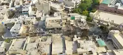 Burned aircraft wreckage distributed across a row of buildings.