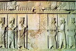 Stone relief depicting two groups of three men facing each other
