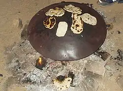 Pita being baked on a convex saj