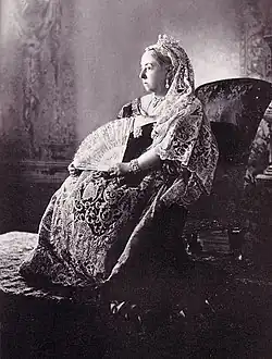 Seated Victoria in embroidered and lace dress