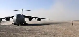 Four-engined jet transport plane on dirt airfield