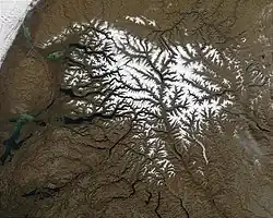 The ranges of the Putorana covered in snow make it stand out among the neighboring lower plateaus. To the upper left the Yenisei valley. NASA image.