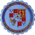 A round seal featuring heraldic symbols on a blue background with a dark blue border
