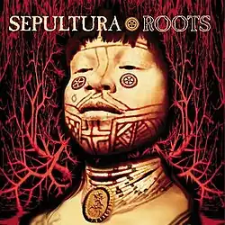 The focus of the cover is the bust of an Amazonian tribesman with native-style facial tattoos and a large number of bead necklaces, including one with a pendant of the band's "S"-shaped logo. The tattoos are mostly line-based with bilateral symmetry but there are two circular designs below the eyes and another ring-like design below his right eye. The necklaces have the same design which consists of mostly white beads but occasionally a green or red bead with black beads adjacent. The bust is actually split in two as the man's neck is transparent, allowing the background to be seen, which consists of a network of arteries in red on a black background. The band name "SEPULTURA" and the album name "ROOTS" appear at the top in an uppercase font (the first filled in and the second in outline) while in-between is the tattoo design that very closely matches the one under the man's left eye.