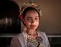 A girl wearing bodo blouse with jewelries; headbands, earrings and necklace