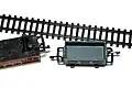 Treble-0-Lectric freight wagon with a miniaturised tension lock coupling beside Arnold N-gauge track.