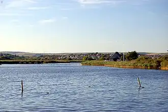 A lake with houses beyond