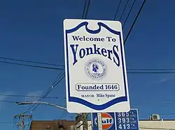 White-and-blue street sign against a blue sky
