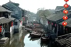Traditional houses along a canal with several boats